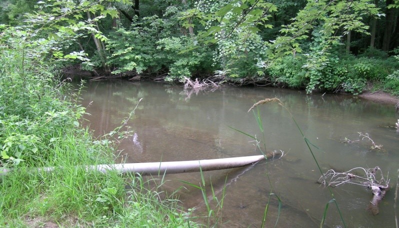 A drain pipe going into a river.